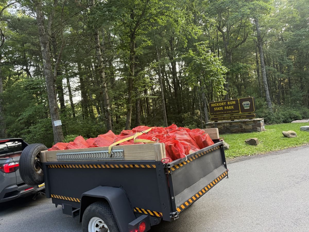 A trailer loaded with bagged firewood parked near the entrance to Hickory Run State Park