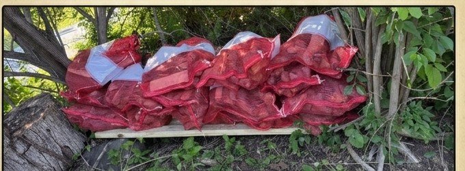 Several bags of pear firewood lined up outdoors ready for delivery