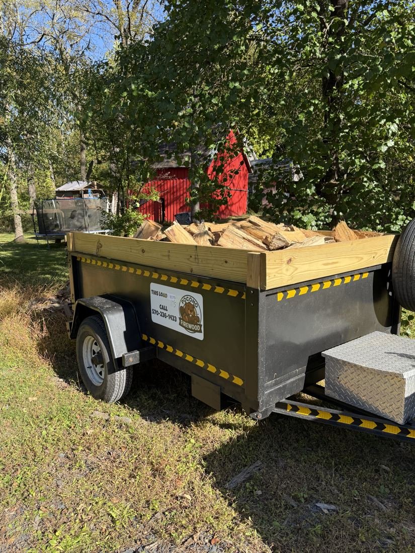 Pocono Firewood branded trailer loaded with a full trailer load of split wood